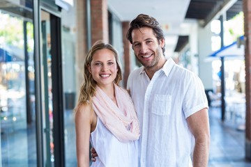 Smiling man putting arm around his girlfriend