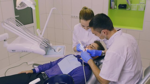 A dentist and an assistant working with the patient in the clinic