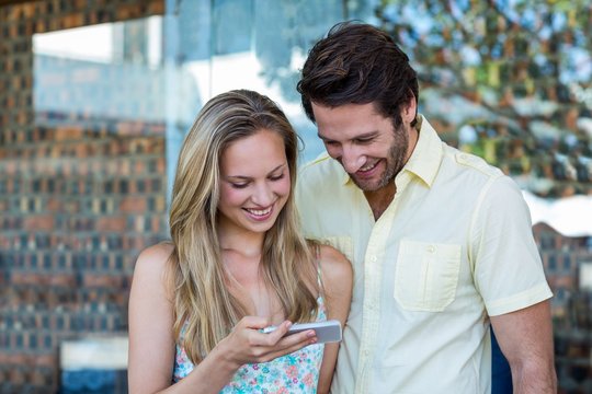 Smiling couple looking at smartphone