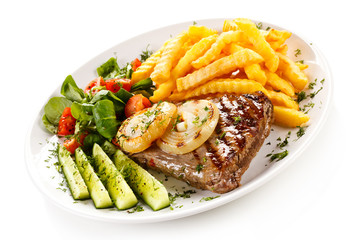 Grilled steak, French fries and vegetables 