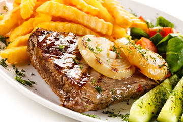 Grilled steak, French fries and vegetables 