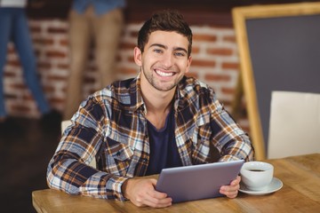 Smiling hipster using tablet computer