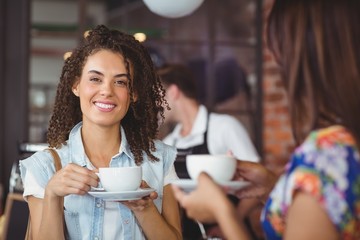 Smiling pretty customer holding cup of coffee