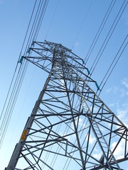 electric high voltage power post with blue sky.