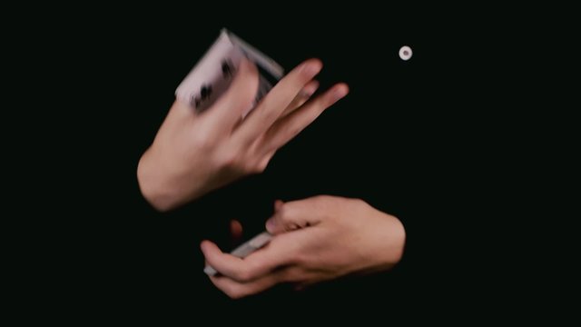 Hands in darkness shuffled deck of cards