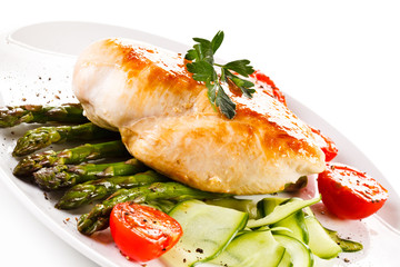 Roast chicken fillet and vegetables on white background 