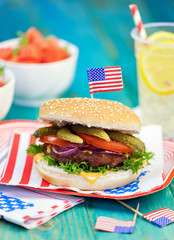 American Burger with cheese,tomato,pickle,red onion,lettuce and Lemonade at a Picnic for 4th of July