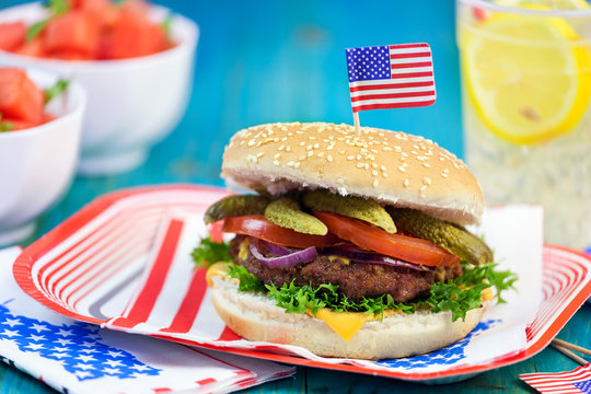 American Burger with cheese,tomato,pickle,red onion,lettuce and Lemonade at a Picnic for 4th of July