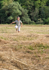 Naklejka na ściany i meble Cute boy running on the meadow, allergy free. Enjoying in nature. Freedom concept.