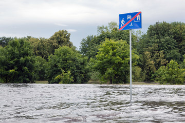 Road sign submerged in flood water in Gdansk, Poland.