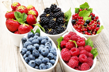 Himbeeren, Erdbeeren, Heidelbeeren, Brombeeren und Johannisbeeren in Schälchen