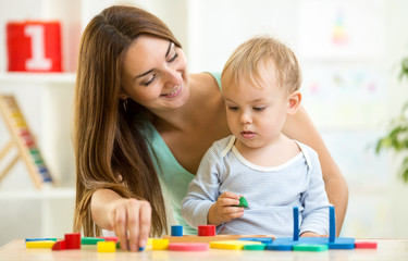 child and mom playing together with puzzle toy