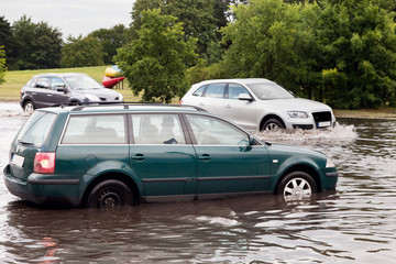 Cars trying to drive against flood on the street in Gdansk, Poland