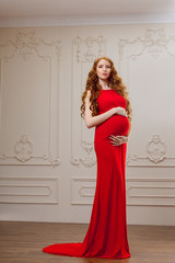 Pregnant fashion model in red dress