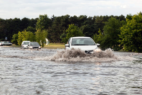 Cars trying to drive against flood on the street in Gdansk, Poland