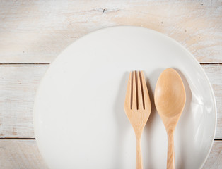 plate with fork and spoon on wood ,with shadows