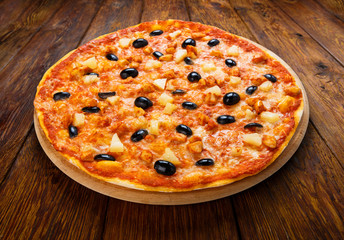 Delicious pizza with pineapple, chicken and olives