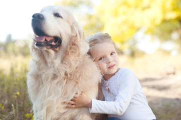 Cute baby girl 3-4 year old with pet outdoors. Childhood.