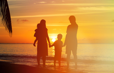 Fototapeta na wymiar happy family with two kids on sunset beach