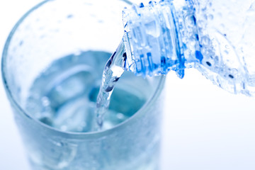 pouring water in an elegant glass with ice and water drops. Macro