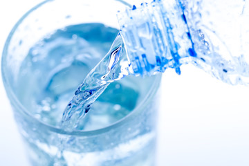 pouring water in an elegant glass with ice and water drops. Macro