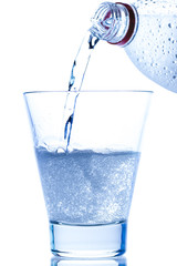 pouring water in an elegant glass with ice and water drops on white background