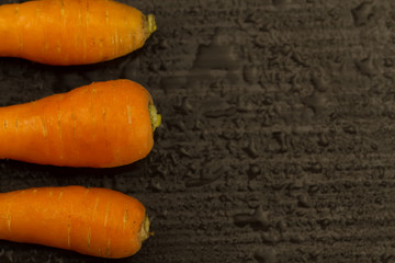 Fresh carrots on a dark brown background. vegetarian food