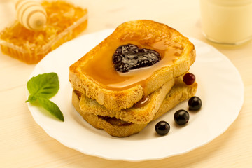 fresh french toast with honey and jam on a white plate with berries. healthy diet