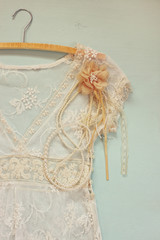 vintage white crochet lace top with hanger on wooden background
