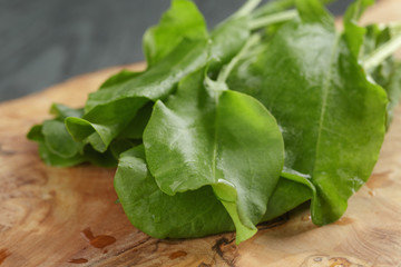 fresh sorrel leaves on cutting board on oak wood table