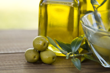 olives and olive oil on wooden background