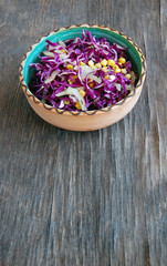 fresh red cabbage salad with sweet corn in ceramic bowl on rustic wooden table