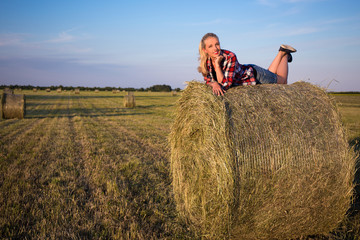 Naklejka na ściany i meble country concept - beautiful romantic woman lying on haystack in