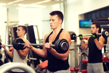 group of men with barbells in gym