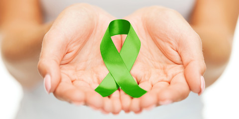 hands holding green awareness ribbon