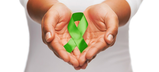 hands holding green awareness ribbon