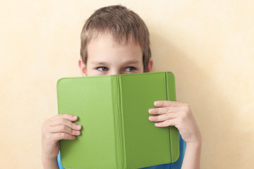 boy reading a book. boy hiding behind the e-book