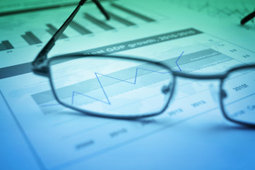 Glasses on financial chart and graph, accounting background