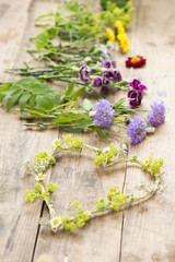 Blumenmit Herz auf einem Holztisch