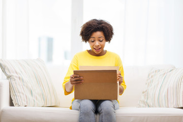 happy african young woman with parcel box at home