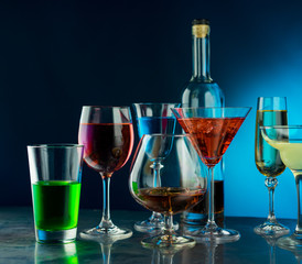 Glasses with different drinks on a blue background