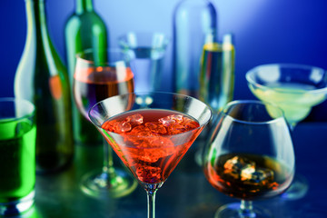 A lot of wine glasses and a bottle of alcohol with different