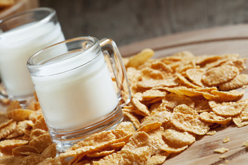 Milk in a cup and corn flakes, selective focus