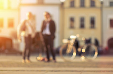 Blurred Couple with bicicle stay on the street at sunny day.