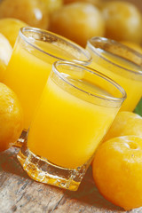 Delicious fresh juice of yellow sweet plums in a glass on the ol