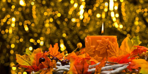 Orange candle in autumn Christmas setting