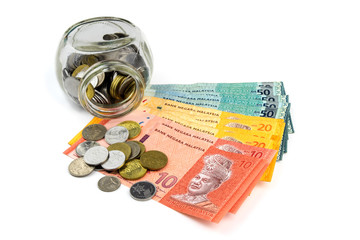 Saving concept. Banknotes and coins with a glass container isolated on white background.