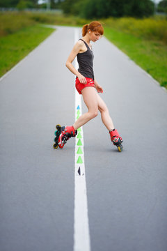 Attractive girl rollerblading on the road