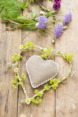 Blumenmit Herz auf einem Holztisch