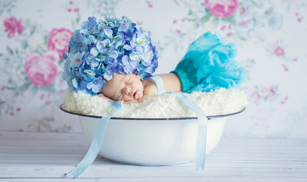 Newborn baby girl with flowers hat asleep